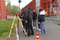Eine Gruppe Schülerinnen steht mit Anton Reitinger vor dem Gebäude des ALE und testet das globale Navigationssatellitensystem.