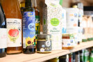 Regal mit Bio-Produkten wie Heumilch, Bratöl, Apfelsaft, Senf