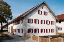 Bild von einem Bauernhaus mit roten Fensterläden