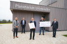 Fünf Männer stehen vor einem Gebäude mit der Aufschrift „Planetarium Ursensollen“ und halten eine Urkunde und einen großen Scheck in den Händen.