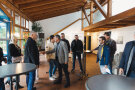 Eine Gruppe von Menschen steht im Gebäude, es werden Hände geschüttelt.