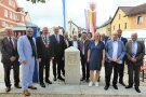 Ein Gruppenbild der Vertreter von Gemeinde, Ämtern und Ministerin vor dem Dorferneuerungs-Denkmal