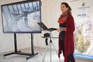 Die Projektleiterin Dr. Schläger-Zirlik steht neben einem Laptop und Bildschirm und hält eine Präsentation.