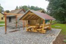 Neue überdachte Sitzgelegenheit mit Tisch aus Holz in einem Dorf.