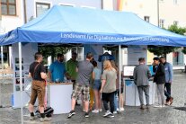 Unter einem Pavillon mit der Aufschrift „Landesamt für Digitalisierung, Breitband und Vermessung“ stehen etwa zehn Personen, die sich an zwei Ständen etwas ansehen.