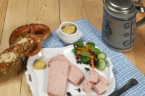 Eine bayerische Zoigl-Brotzeit mit Leberkäse, Breze und einem Bierkrug. 