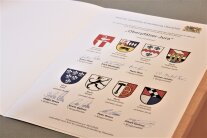 Eine Urkunde zeigt acht Wappen und acht Unterschriften. 
