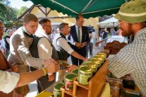 An einem Verkaufsstand stehen vier Personen und probieren etwas.