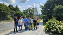 Viele Personen stehen unter freiem Himmel an einer Straße innerhalb eines Ortes. 