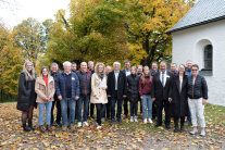 20 Personen haben sich unter freiem Himmel zum Gruppenbild aufgestellt.