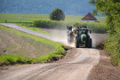 Traktor mit Anhänger fahren auf Flurweg, des Bankett nachbearbeitet wurden.