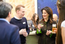 Ministerin Michaela Kaniber hat ein kleines Glas in de Hand und spricht mit einem Herren von Lammsbräu