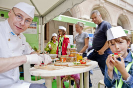 Koch bereitet einem Kind ein Pausenbrot zu